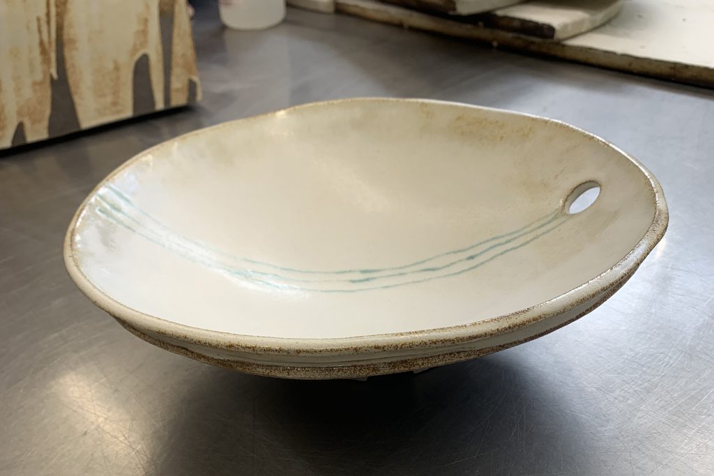 Medieval serving bowl, cream glaze with a hint of turquoise glaze on dark granite clay.