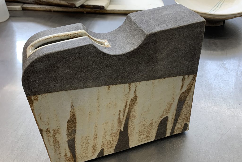 Art Deco square sculpture, cream glaze on dark granite clay.
